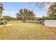 Spacious backyard featuring green grass, mature trees, and a wooden fence for privacy at 96 Pecan Dr, Ocala, FL 34472