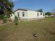 Single-story home with a well-maintained exterior and a neat backyard featuring landscaping and comfortable outdoor seating at 361 Wade Park Ct, Davenport, FL 33897