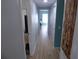 Inviting hallway showcasing wood flooring and neutral paint, leading to various rooms in the home at 361 Wade Park Ct, Davenport, FL 33897