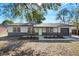 Charming home with a green front door, gray brick trim, covered porch, and a freshly landscaped yard at 1203 Baranova Rd, Ocoee, FL 34761