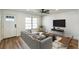 Bright living room featuring wood floors, a ceiling fan, and a modern gray couch at 1203 Baranova Rd, Ocoee, FL 34761