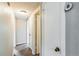 Hallway featuring multiple white doors, neutral paint, and overhead lighting at 1205 Flewelling Ave, Ocoee, FL 34761