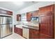 Modern kitchen featuring stainless steel appliances, farmhouse sink, dark wood cabinets, and a stylish backsplash at 1205 Flewelling Ave, Ocoee, FL 34761