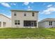 Backyard view of a two-story home featuring a screened lanai and a spacious lawn area at 1212 Bear Oak Ln, Deland, FL 32720