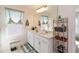 Well-lit bathroom offers double sinks, white cabinets, and a large mirror at 1212 Bear Oak Ln, Deland, FL 32720