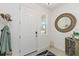 Bright entryway featuring a decorative mirror, coat rack, and a glimpse of the outdoors through a window at 1212 Bear Oak Ln, Deland, FL 32720