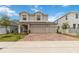Two-story home featuring a three-car garage, neutral paint, brick driveway, manicured lawn and flower beds at 1212 Bear Oak Ln, Deland, FL 32720