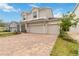 Two-story home with a brick driveway, three-car garage, manicured lawn and well-maintained landscaping at 1212 Bear Oak Ln, Deland, FL 32720