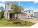 Charming two-story home with a three-car garage, covered front porch with seating, and landscaped yard at 1212 Bear Oak Ln, Deland, FL 32720