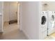Laundry area with modern stacked washer and dryer units next to entry at 1212 Bear Oak Ln, Deland, FL 32720