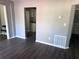 Open living room showcasing gray walls and floors, with a view into the adjacent kitchen at 1219 Dewey Ave, Orlando, FL 32808