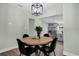 Dining area with a modern chandelier, round wooden table with seating for four, open to the kitchen at 1240 Moton Ave, Sanford, FL 32771