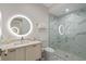 Modern bathroom with a glass enclosed shower, marble tile, and illuminated mirror at 1297 Grand Traverse Pkwy, Reunion, FL 34747