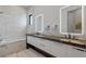 Modern bathroom with dual sinks, dark countertop, and marble-tiled bathtub at 1297 Grand Traverse Pkwy, Reunion, FL 34747