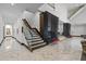 Bright foyer with marble floors, staircase with glass railing, and decorative wood slats feature wall with seating at 1297 Grand Traverse Pkwy, Reunion, FL 34747