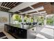 Modern outdoor kitchen featuring a large island, sink and dining table under a pergola at 1297 Grand Traverse Pkwy, Reunion, FL 34747