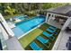 Aerial view of a luxurious pool area with multiple pools, lounge chairs, and a covered patio at 1297 Grand Traverse Pkwy, Reunion, FL 34747