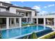 Stunning modern home featuring a large pool, lounge chairs, and beautifully landscaped backyard perfect for relaxation at 1297 Grand Traverse Pkwy, Reunion, FL 34747