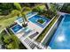 Aerial view of a stunning pool area with a spa, sun loungers, and lush landscaping at 1297 Grand Traverse Pkwy, Reunion, FL 34747