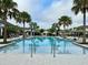 Large community pool surrounded by palm trees and lounge chairs for relaxation and enjoyment at 1344 Blue Stem Lane, Winter Park, FL 32792