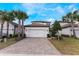 Charming two-story home with lush palm trees and a brick paved driveway offers curb appeal at 1344 Blue Stem Lane, Winter Park, FL 32792