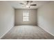 This neutral bedroom features carpet flooring, a window, and a ceiling fan with a light at 13441 Starry Night Ct # 9, Orlando, FL 32824