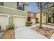 Exterior view of colorful townhomes with driveways, garages, and landscaped front yards at 13441 Starry Night Ct # 9, Orlando, FL 32824