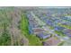 Neighborhood aerial view showing a tree-lined street with sidewalks, well-maintained homes, and a nearby lake at 14031 Jomatt Loop, Winter Garden, FL 34787