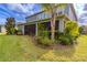 Lovely backyard featuring a screened-in porch, beautiful lawn, and lush landscaping at 14031 Jomatt Loop, Winter Garden, FL 34787