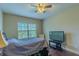 Cozy bedroom with hardwood floors, natural light, and a television at 14031 Jomatt Loop, Winter Garden, FL 34787