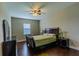 Cozy bedroom featuring a ceiling fan, a window with blinds, and beautiful dark wood furniture at 14031 Jomatt Loop, Winter Garden, FL 34787