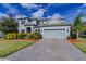 Charming two-story home featuring a well-manicured lawn, mature landscaping, and a two-car garage at 14031 Jomatt Loop, Winter Garden, FL 34787