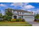 Charming two-story home featuring a well-manicured lawn, mature landscaping, and a two-car garage at 14031 Jomatt Loop, Winter Garden, FL 34787