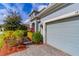 Close up of a well-maintained garage with lovely landscaping and brick driveway at 14031 Jomatt Loop, Winter Garden, FL 34787