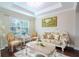 Cozy living room featuring plush seating, a large window, and tray ceiling at 14031 Jomatt Loop, Winter Garden, FL 34787