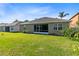 View of the expansive backyard, featuring lush green grass, mature landscaping, and a screened-in lanai at 150 Magnolia Park Trl, Sanford, FL 32773