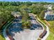 Aerial view of gated community entrance featuring lush trees, manicured landscaping, and brick entryway at 150 Magnolia Park Trl, Sanford, FL 32773