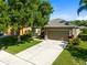 View of the home featuring a well-maintained lawn and paved driveway at 150 Magnolia Park Trl, Sanford, FL 32773