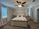 Comfortable bedroom featuring a large bed, ceiling fan, neutral color scheme, and ample natural light at 2006 Myrtle Pine St, Kissimmee, FL 34746