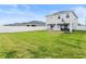 Expansive backyard featuring green lawn, white vinyl fence, covered patio and basketball hoop at 207 Polermo Ave, St Cloud, FL 34771