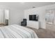 The main bedroom featuring a bed, television, comfortable chair, and doorways to a closet and bathroom at 207 Polermo Ave, St Cloud, FL 34771