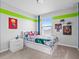 A colorful bedroom decorated with superhero themes, featuring a window with blinds and carpeted floors at 207 Polermo Ave, St Cloud, FL 34771