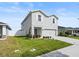 Well-manicured lawn and shrubbery enhance the curb appeal of this charming two-story home at 207 Polermo Ave, St Cloud, FL 34771