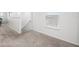 Carpeted hallway with natural light, featuring a view of a staircase and a window with blinds at 207 Polermo Ave, St Cloud, FL 34771