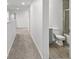 Carpeted hallway leading to a bathroom with a shower-tub combination, offering a view of the neutral decor at 207 Polermo Ave, St Cloud, FL 34771