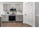 This is a detailed view of the kitchen with light gray cabinets, stainless appliances, and hard wood floors at 207 Polermo Ave, St Cloud, FL 34771