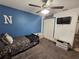 This bedroom has a ceiling fan, a closet, and a bed with a blue accent wall at 2413 Sandridge Cir, Eustis, FL 32726