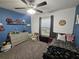 A bedroom featuring a ceiling fan, plush gray carpet, and blue accent wall at 2413 Sandridge Cir, Eustis, FL 32726