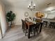 Well-lit dining room boasts wood floors, chandelier, and neutral walls, ideal for comfortable meals at 2413 Sandridge Cir, Eustis, FL 32726