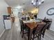 Inviting dining room featuring wood floors, chandelier lighting, and an open view to the kitchen at 2413 Sandridge Cir, Eustis, FL 32726